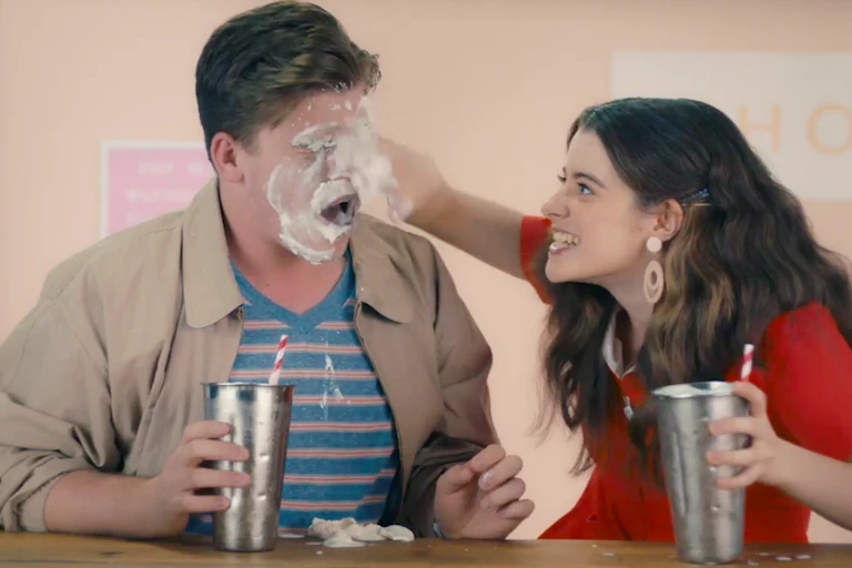 Girl smearing milkshake over boy's face