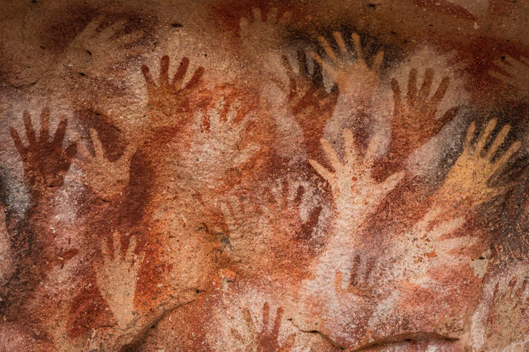 A number of hand stencils on a cave wall