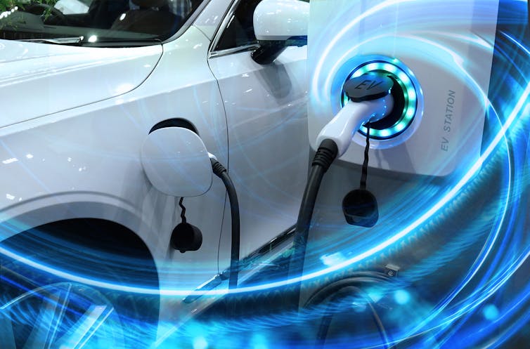 An electric car charging port plugged into a socket.
