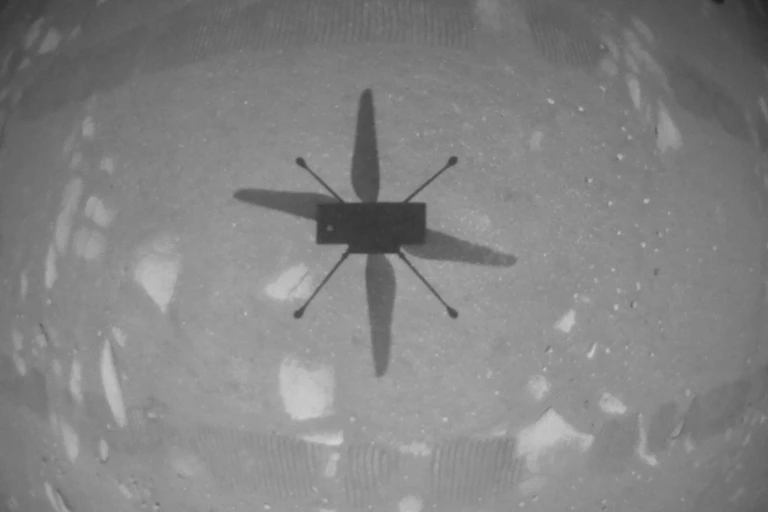 Image of NASA’s Ingenuity Mars Helicopter as it hovers over the Martian surface.