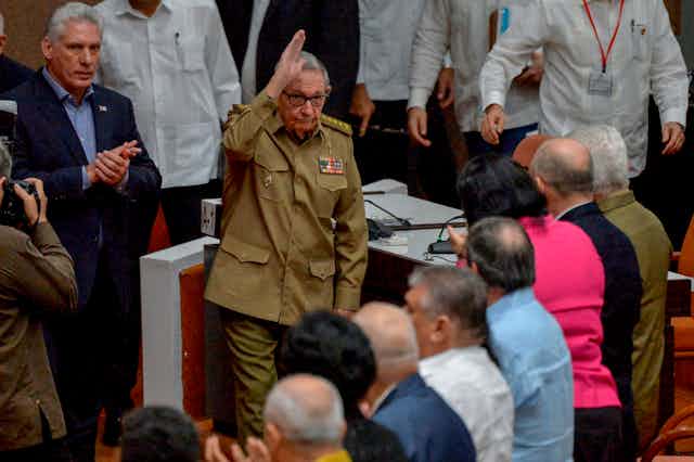 Castro, in military fatigues, waves at other government officials