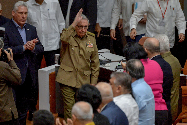 Castro, in military fatigues, waves at other government officials