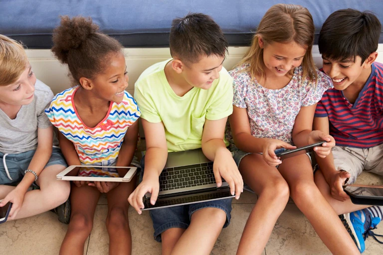 Five children using digital devices