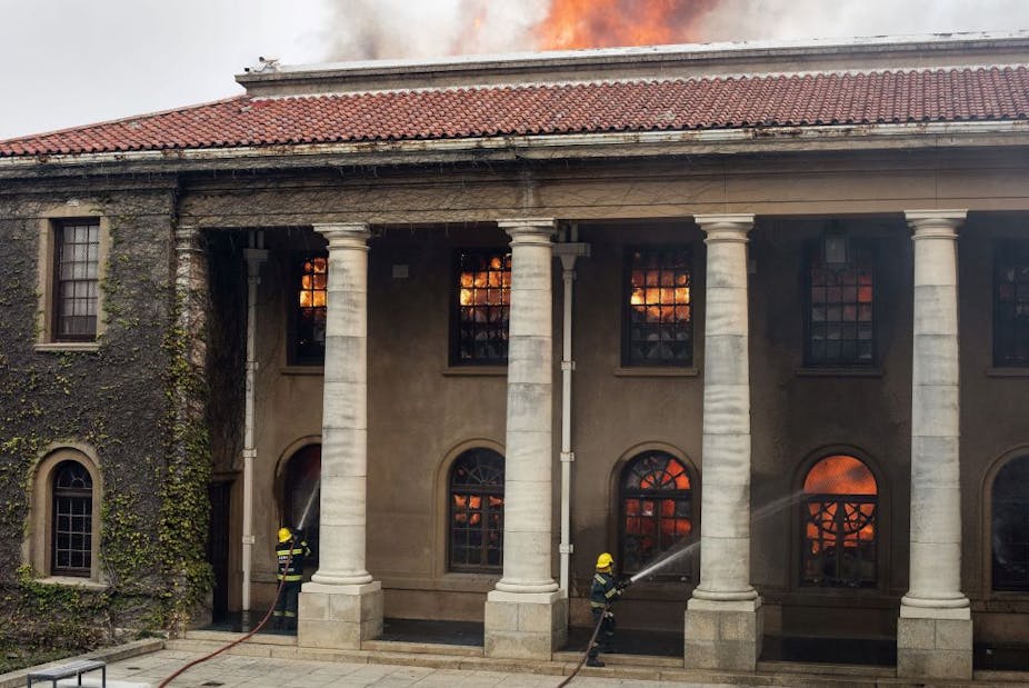 A historic university building engulfed in flames. alight