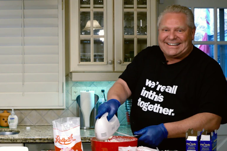 Man baking wearing tshirt that reads we're all in this together