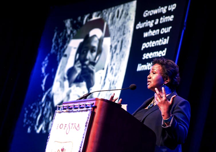 An African American woman speaks at a conference.