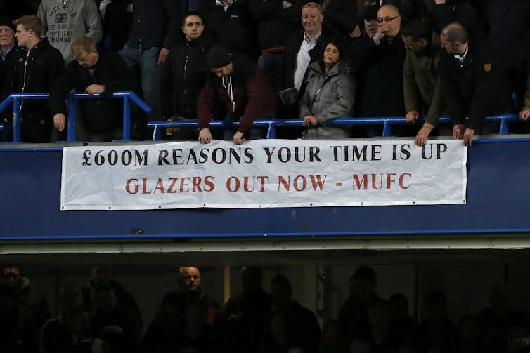 Manchester United fans unfurl a banner against the Glazer ownership of the club.