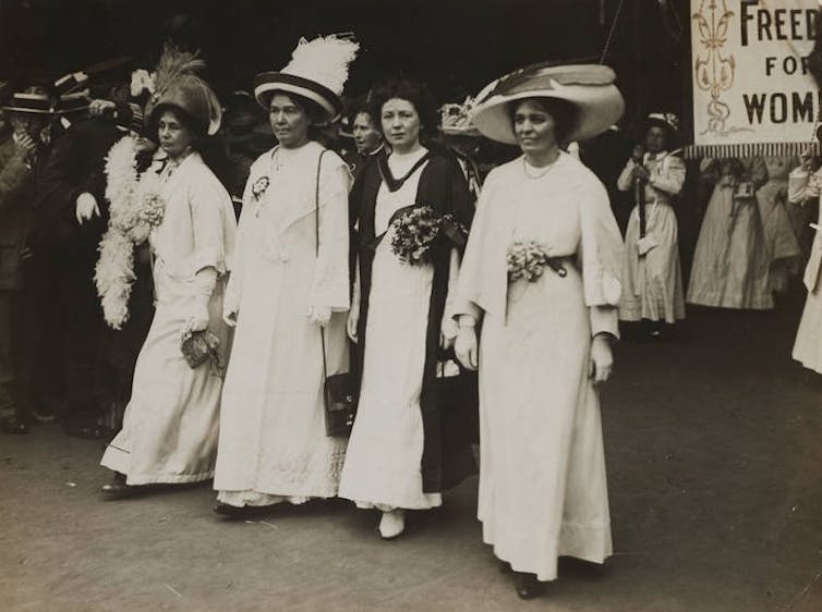 Four white women in brilliant white dresses