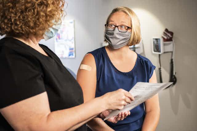 A doctor speaks to a woman after her vaccine.