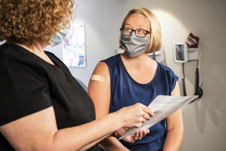 A doctor speaks to a woman after her vaccine.