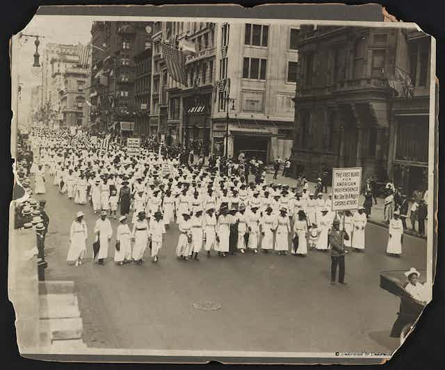A parade of black women in white.