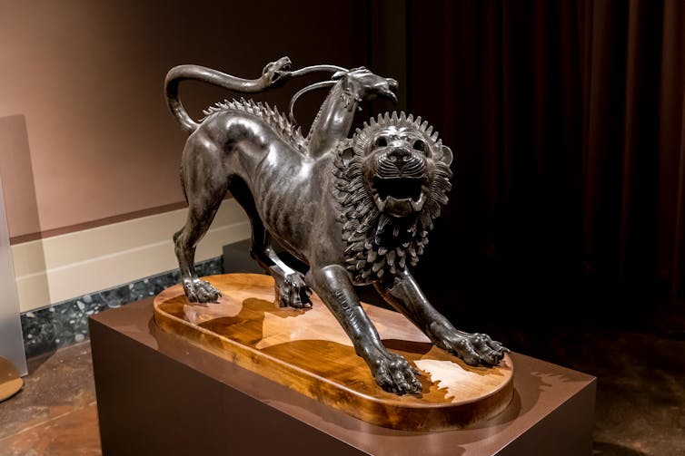 A bronze statue of a Chimera in a museum