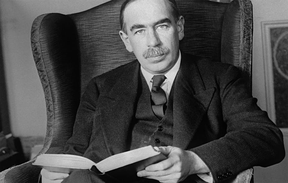 John Maynard Keynes reading a book on an armchair