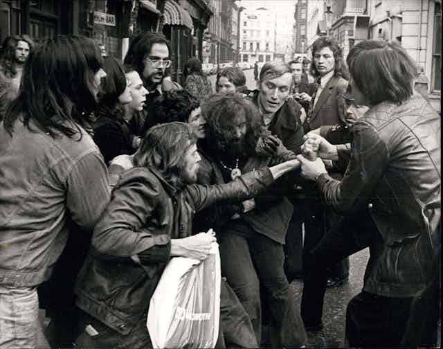 Black and white 1970s photo of a group of men in a struggle
