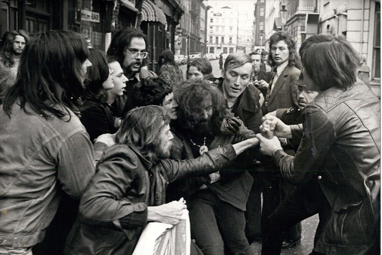Black and white 1970s photo of a group of men in a struggle