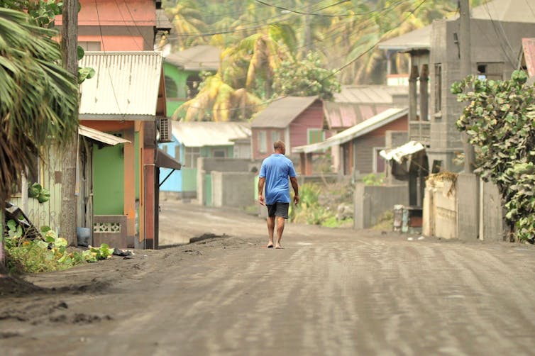 A man walks down a street after a series of eruptions from La Soufrière volcano covered the area with a thick layer of ash.