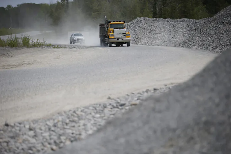 Truck drives down gravel road