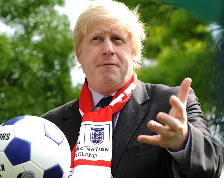 Boris Johnson holding a football wearing an England scarf