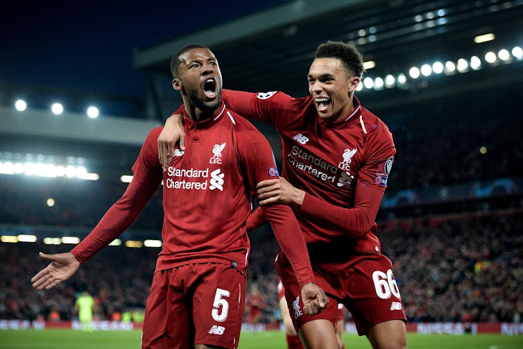 Liverpool's Georginio Wijnaldum celebrates on the pitch with his teammate Trent Alexander-Arnold.