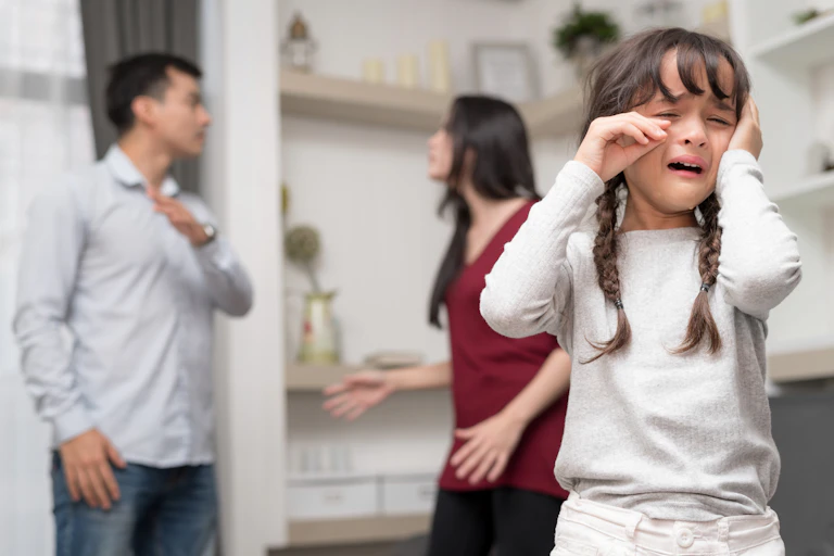 Child in foreground as parents fighting in background