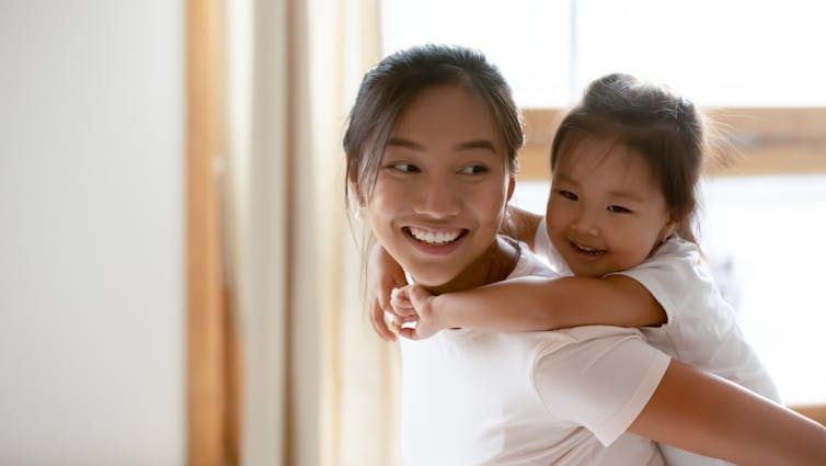 Mother giving a piggyback to child