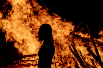 Woman's silhouette in front of fire