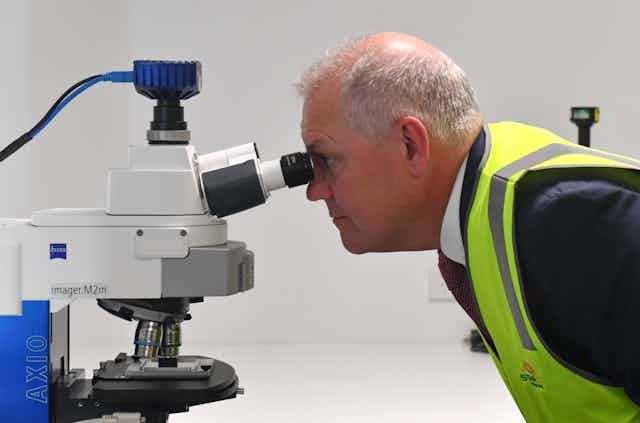 Scott Morrison, looking into a microscope