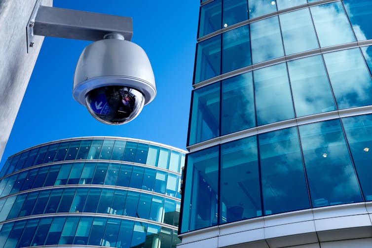 A CCTV camera in a city centre surrounded by high-rise offices
