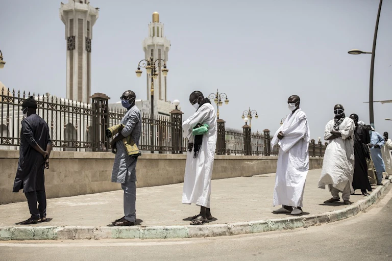 Des fidèles font la queue pour se laver les mains avant la prière du vendredi à la mosquée des Mourides, qui ouvre pour ses premières prières du vendredi après deux mois à Dakar, le 15 mai 2020.