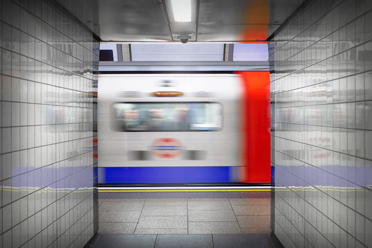 A tube train rushes past a tiled tunnel on the London Underground