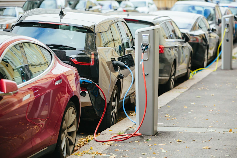Coches eléctricos aparcados y recargando baterías.