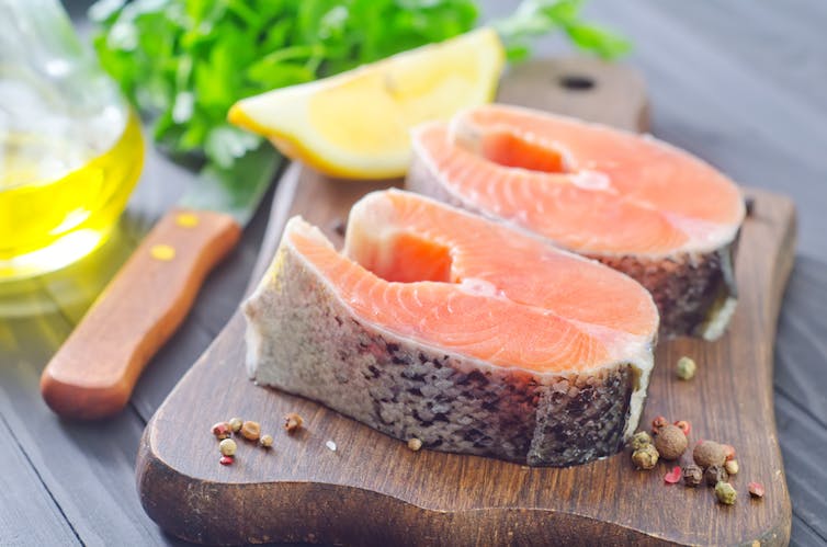 Two pieces of salmon with lemon wedge