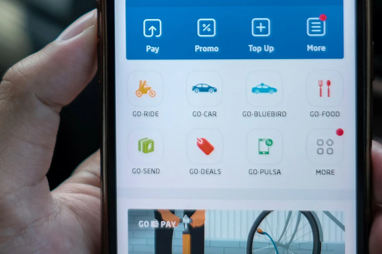 Hand holding a smartphone showing multiple transport service options