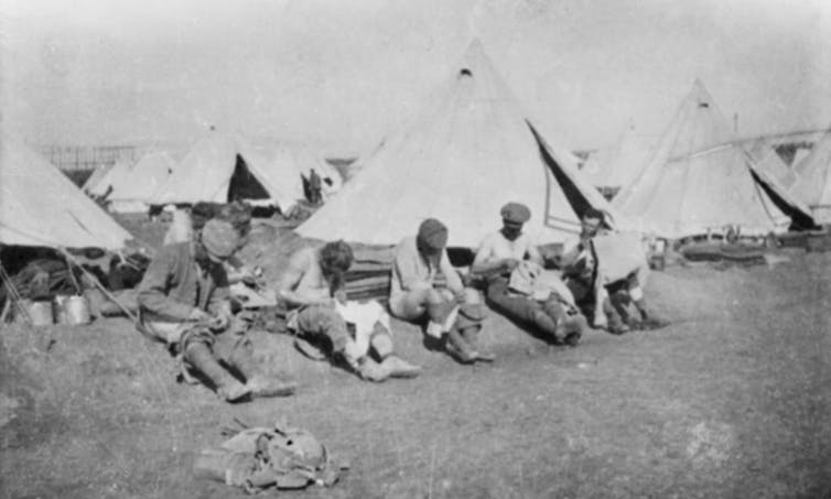 Soldiers delousing clothing outside tents