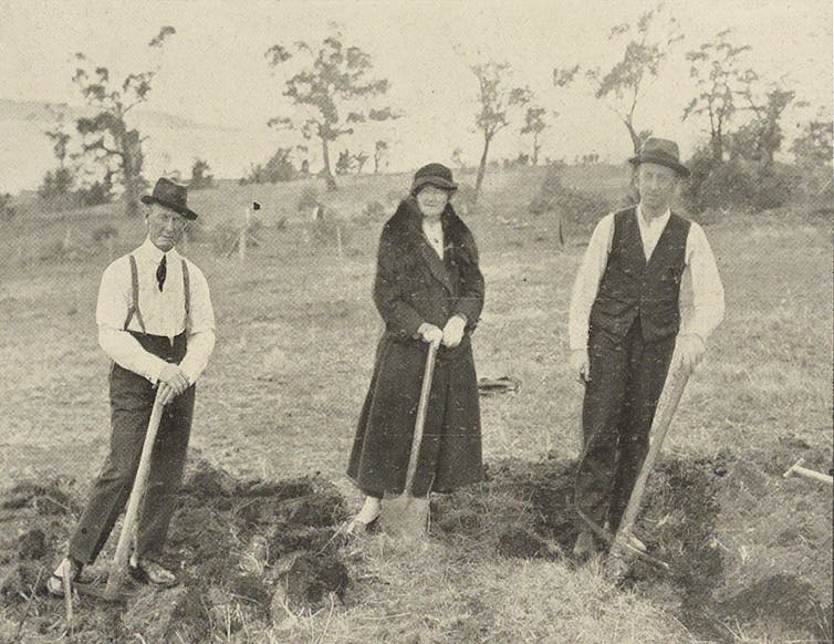 Three people holding shovels