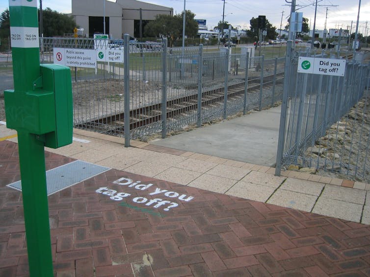 public transport station with the words 'Did you tag off?' painted on the pavement