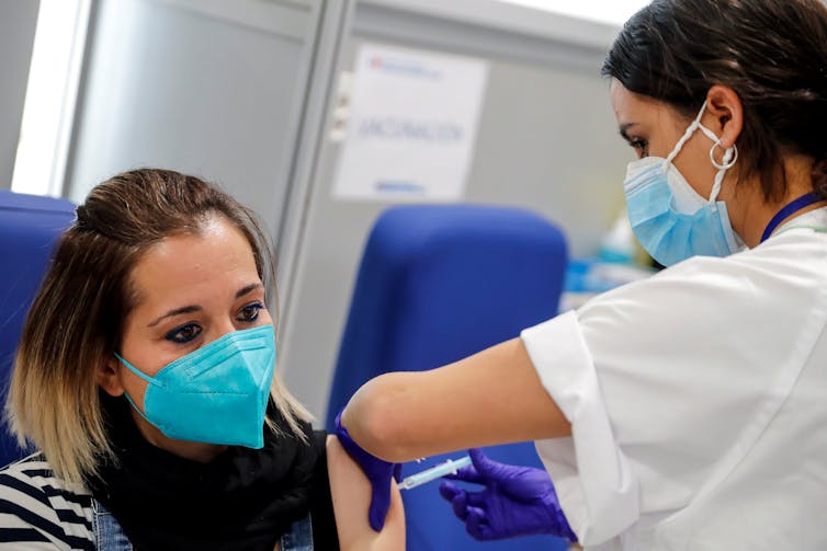 A young woman being vaccinated with the AstraZeneca vaccine