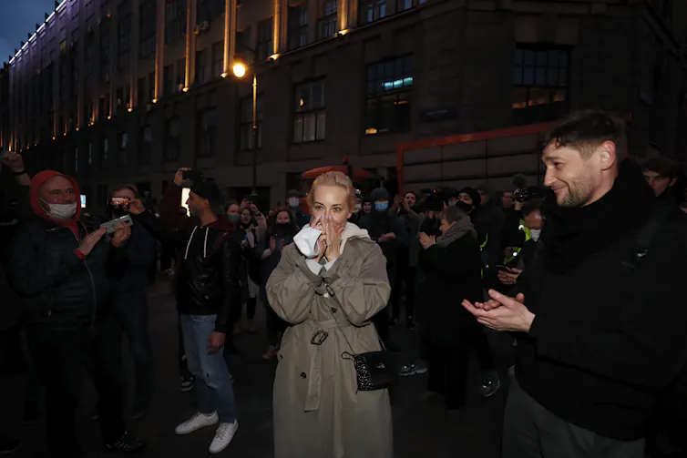 Yulia Navalnaya, wife of the Russian jailed opposition leader Alexei Navalny, covers her mouth as fellow protesters applaud.