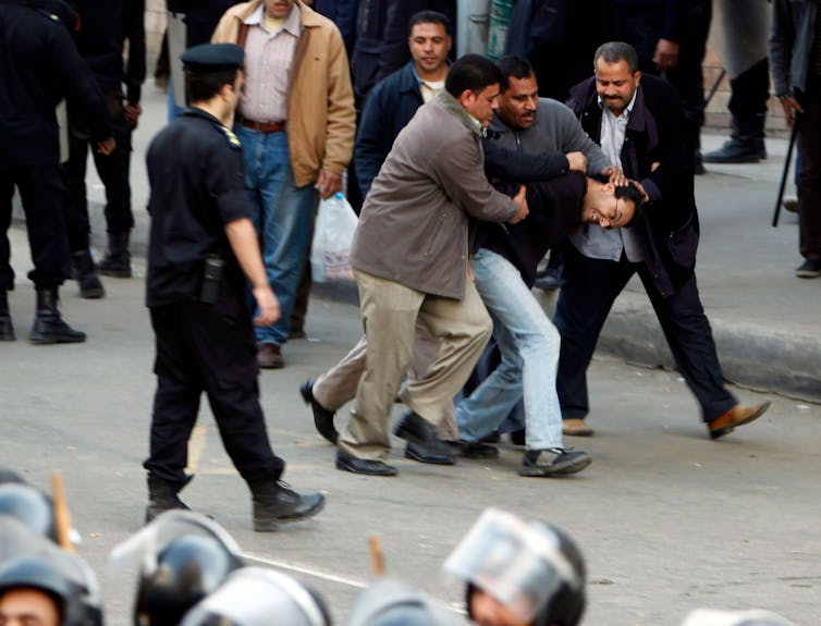 Men in a struggle during a protest in Egypt