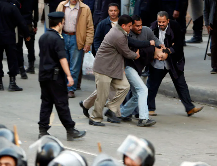 Men in a struggle during a protest in Egypt