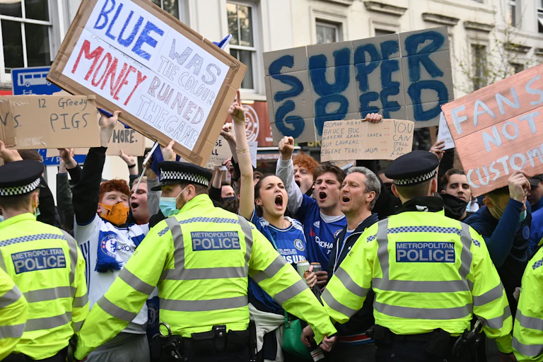 Protesting football fans held back by a line of police.