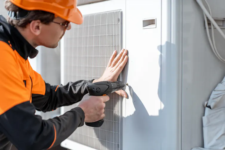 An engineer installing a heat pump.