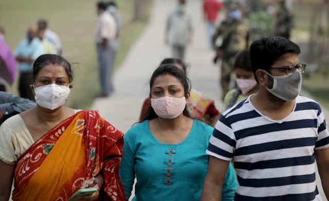 People in India walking outside wearing masks
