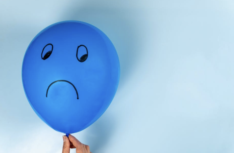 Blue balloon with a sad face on it