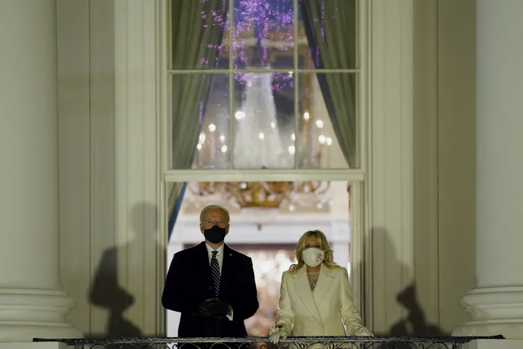 Joe and Jill Biden watch fireworks from a balcony at the White House.