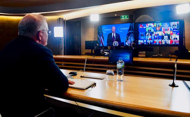 Scott Morrison in front of screens featuring Joe Biden and other leaders