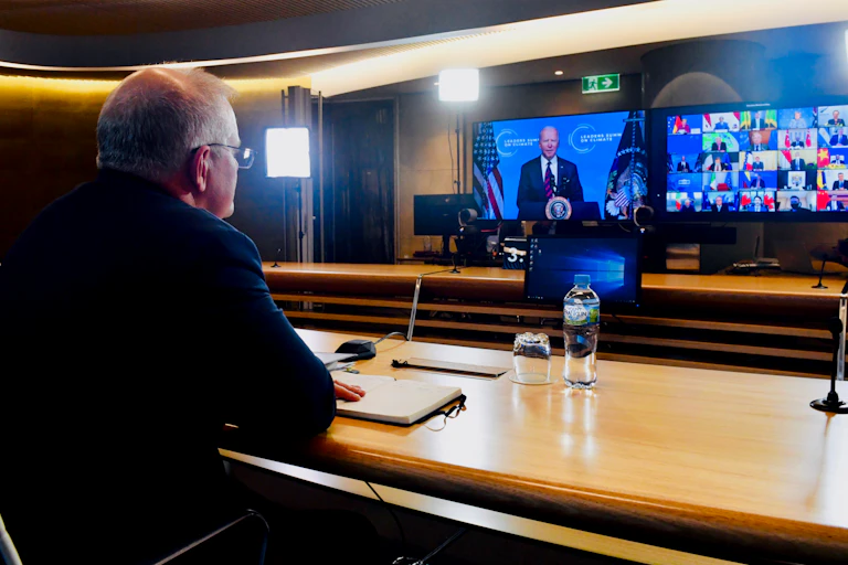 Scott Morrison in front of screens featuring Joe Biden and other leaders