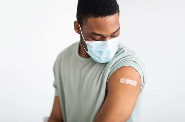 Vaccinated man looking at the plaster on his arm