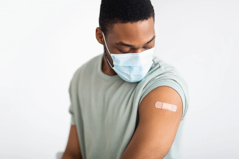 Vaccinated man looking at the plaster on his arm