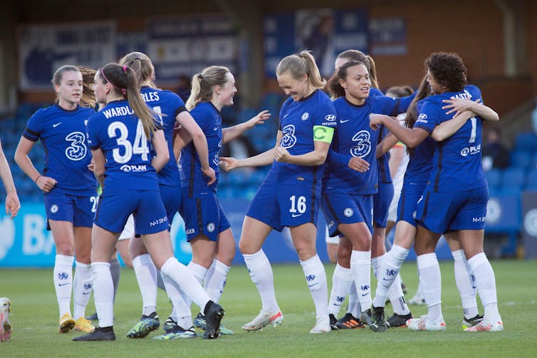 Women footballers congratulate each other.